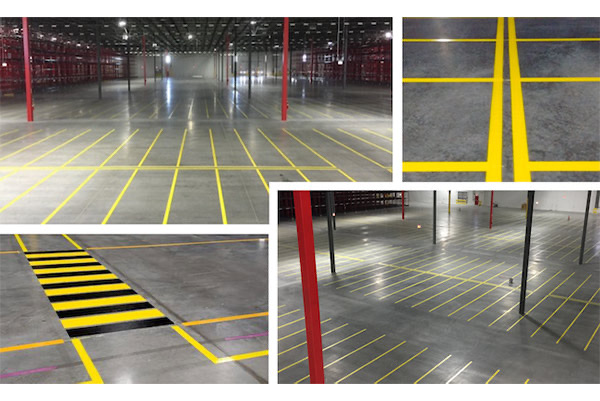 Warehouse floor with yellow aisle striping and a black-and-yellow hatched safety zone on polished concrete